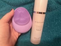 Avis client satisfait PureGlow - Femme avec brosse sonique rose fond dégradé